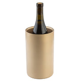 A dark wine bottle stands upright in a tall, gold coated stainless steel wine cooler with a smooth, matte finish. The bottle’s cork is sealed and part of its label is visible against the crisp white background.