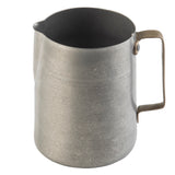 A plain stainless steel frothing cup with a narrow spout and a sturdy, angular handle attached on one side. The pitcher has a brushed, slightly worn surface and sits on a white background.