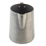 A stainless steel frothing cup with a brushed finish features a rounded body, a small pouring spout, and two visible rivets inside near the rim that secure the handle on the opposite side (not visible in this view).