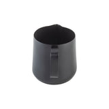 A matte black stainless steel frothing cup with a sturdy handle, seen from above on a white background. The pitcher features a nonstick PTFE coating, a spout for pouring, and a simple, modern design.