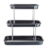 A minimalist and functional 3-tier Sharing Tower with black trays and stainless steel supports. The rectangular trays decrease in size from bottom to top, perfect for serving or organizing food and items.