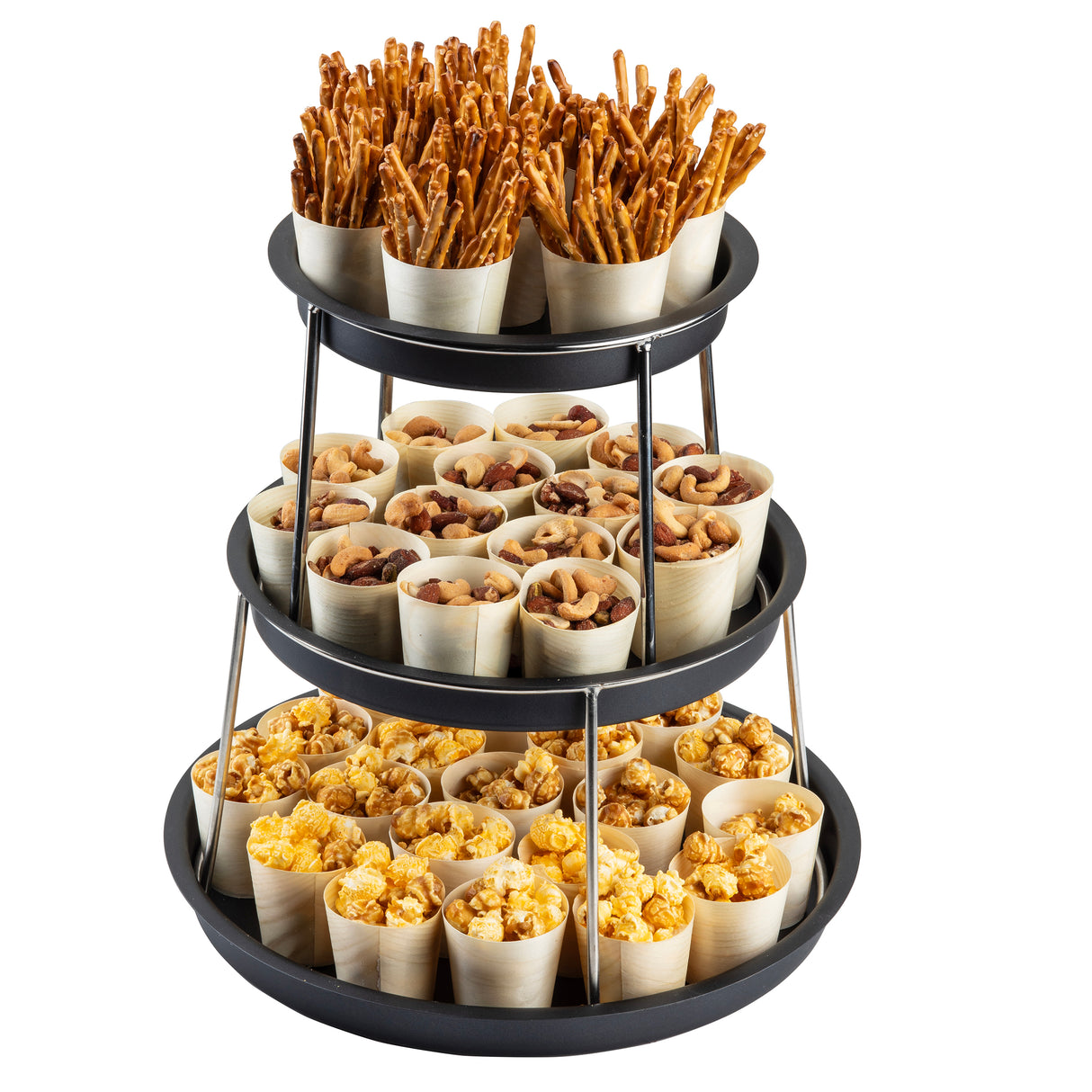 A 3-tier Sharing Tower with a black finish holds small wooden cups; the top tier has pretzel sticks, the middle has mixed nuts, and the bottom is filled with yellow popcorn. Each stainless steel tier neatly displays evenly arranged snack-filled cups.