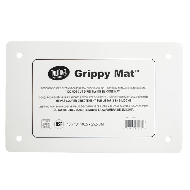 A white rectangular Grippy Mat Cutting Board by TableCraft, this anti-slip cutting mat features printed instructions in English, French, and Spanish, four reinforced corner holes, and measures 16 x 10" (40.5 x 25.5 cm).