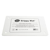 A rectangular white silicone Grippy Mat Cutting Board with rounded edges, four corner holes, and a centered label displaying the TableCraft logo, product name, care instructions in three languages, NSF logo, and mat size: 16 x 10 (40.5 x 25.5 cm).