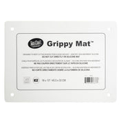 A rectangular white Grippy Mat Cutting Board by TableCraft. This anti-slip cutting mat features rounded corners, four corner holes, and a multilingual label with use and care instructions. Size: 18x13 in (45.5x33 cm).