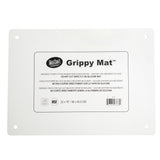 A rectangular white silicone imprinted mat with rounded corners and four holes, one near each corner. The center label reads “TableCraft Grippy Mat” with usage instructions and dimensions: 22 x 16 inches—an ideal anti-slip cutting board mat.