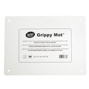 A rectangular white silicone imprinted mat with rounded corners and four holes, one near each corner. The center label reads “TableCraft Grippy Mat” with usage instructions and dimensions: 22 x 16 inches—an ideal anti-slip cutting board mat.