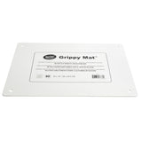 A rectangular white silicone imprinted cutting board mat labeled “Grippy Mat” lies flat. It features anti-slip properties, rounded corners, a hole in each corner, and a central label with product info and measurements: 22 x 16 in / 55 x 40.5 cm.