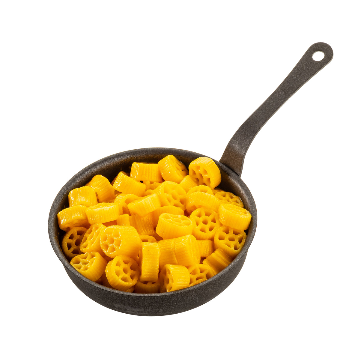 A small black non-stick fry pan with a long handle is filled with bright yellow, wheel-shaped pasta pieces, all piled together. The cooked pasta sits in the Mini Serving Fry Pan by TableCraft Products, isolated on a white background.