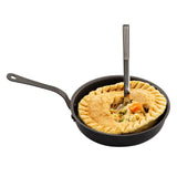 A Mini Serving Fry Pan by TableCraft holds a round pot pie with a golden-brown crust. A fork stands upright in the middle, exposing the filling of carrots and peas. The background is plain white.
