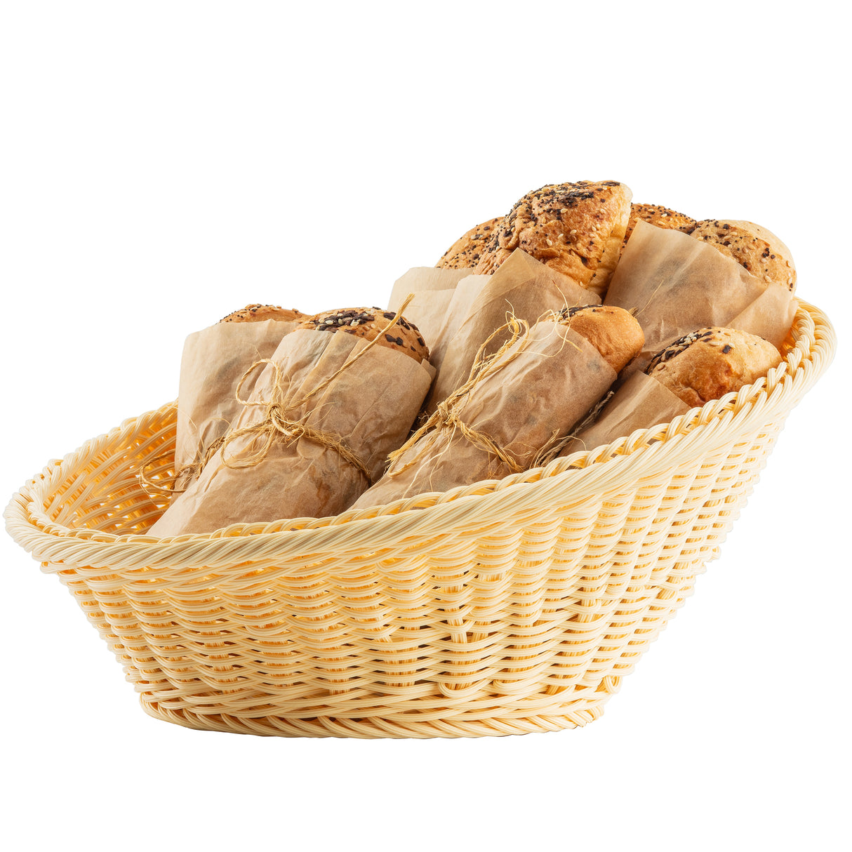 A handwoven basket holds several loaves of bread wrapped in brown parchment paper and tied with twine. The bread has a golden crust, some topped with seeds, and the basket is set against a plain white background.