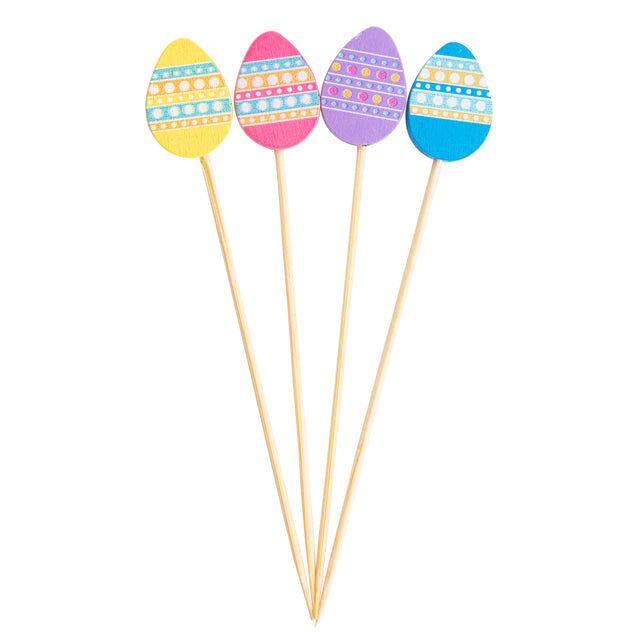 Four wooden Decorative Picks, each topped with a colorful Easter egg—yellow, pink, purple, and blue. Each egg features white stripes and dotted patterns, fanned out neatly on a white background. Perfect for festive TableCraft Products displays.