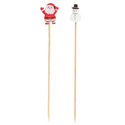 Two vertical decorative picks are shown: the left is topped with a cartoon Santa, the right with a smiling snowman. These festive bamboo picks make charming holiday party supplies for snacks or desserts.