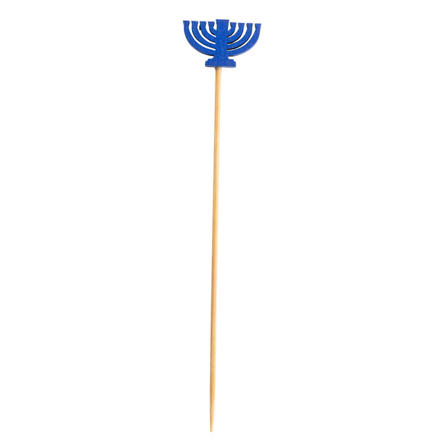 A wooden skewer from TableCraft Products with a blue menorah decoration made of paper or plastic at the top. This decorative pick features a stylized nine-branch menorah, symbolizing Hanukkah, set against a plain white background.
