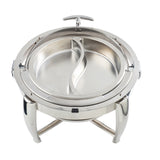 A round stainless steel chafer with a clear dripless roll top lid, shown open. Inside are two curved compartments. The dish stands on three sturdy, arched legs and boasts a modern design, perfect for serving hot food at buffets or events.