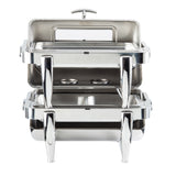 A stainless steel chafer with two tiers is shown. The top tier’s lid is open, revealing an empty warming tray inside. The bottom tier is closed. Both tiers have sturdy, angled legs and a polished, reflective finish.