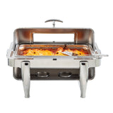 A 9 qt stainless steel chafer filled with baked lasagna sits on a stand with two fuel holders beneath. The dripless roll top chafer has an open lid with a handle on top, and a serving spatula rests inside the lasagna.