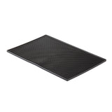 A rectangular black rubber service mat with a grid of small raised bumps, shown on a white background. Slightly elevated along one edge for flexibility, this mat is designed for traction or drainage and is dishwasher safe for easy cleaning.