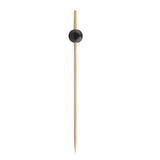 A single TableCraft Products Ball Pick, crafted from bamboo and pinewood, stands vertically with a pointed end and a small round black bead near the top. The plain white background highlights its simple, minimalistic design.