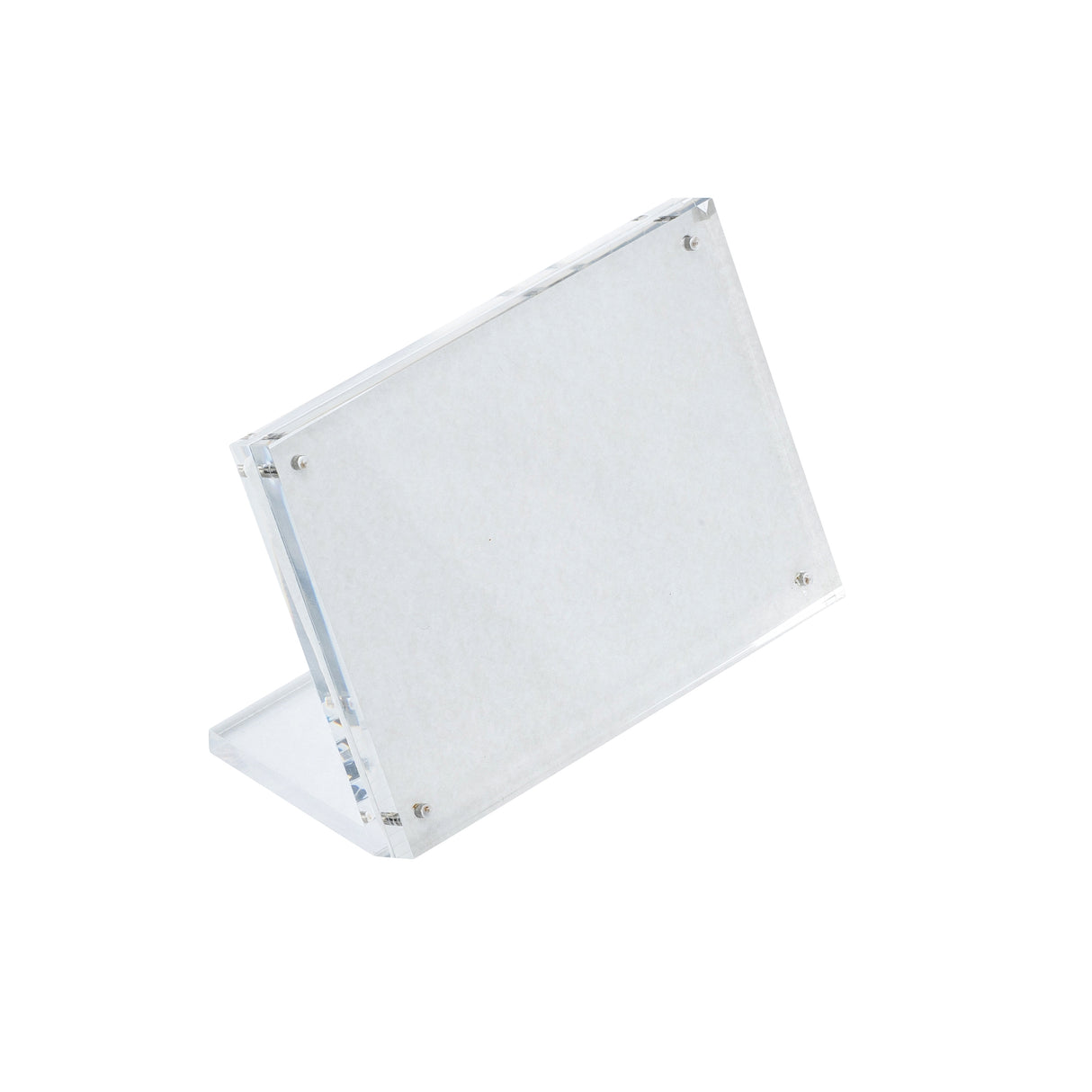 A TableCraft Acrylic Sign Holder stands at an angle with a rectangular display area, supported by a transparent L-shaped base. Four small inset magnets are visible at the corners, securing the front and back panels together. The background is white.