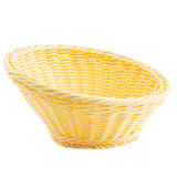 A shallow, oval-shaped handwoven basket in light yellow features a tightly woven pattern and a smooth, slightly slanted rim. The plain white background highlights the basket’s texture and shape, emphasizing its unique TableCraft style.