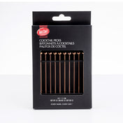 A black box labeled “TableCraft Cocktail Picks” displays twelve gold-toned stainless steel picks inside. The packaging features white text in English, French, and Spanish, plus a window revealing the picks arranged neatly in a row.