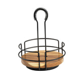A modern, minimalist TableCraft 12267 acacia wood caddy with a black metal frame, open sides, and a circular wooden base. The tall, curved handle features a coiled grip—perfect as a rotating tabletop caddy for napkins or condiments.
