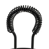 Close-up of a black metal object, resembling the arch on a rotating tabletop caddy, with two vertical rods joined by a tightly wound curly coil against a white background. The spring-like coil forms an evenly spaced, symmetrical design.