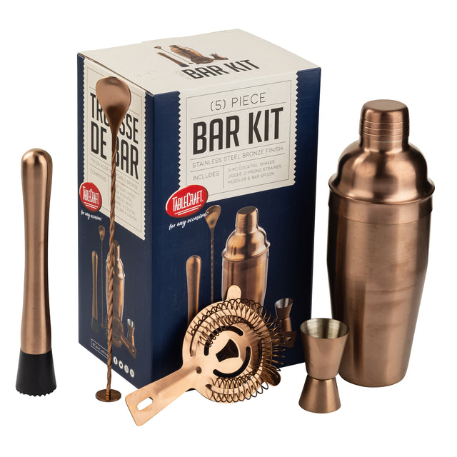 A five-piece stainless steel bar kit with a bronze finish is displayed next to its box. The set includes a cocktail shaker, muddler, twisted spoon, strainer, and jigger. The box reads “BAR KIT” and shows the shaker and utensils on the front.