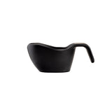 A matte black, modern measuring cup made of durable melamine features a curved body, wide pouring spout, and ergonomic handle that slopes downward. Set against a white background, its sleek, stackable design is clearly visible in side profile.