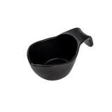 A matte black ceramic sauce boat with a rounded body and integrated, curved handle, shown angled on a plain white background. The thick, ergonomic handle and slightly tapered spout make pouring easy. Stackable for convenient storage.