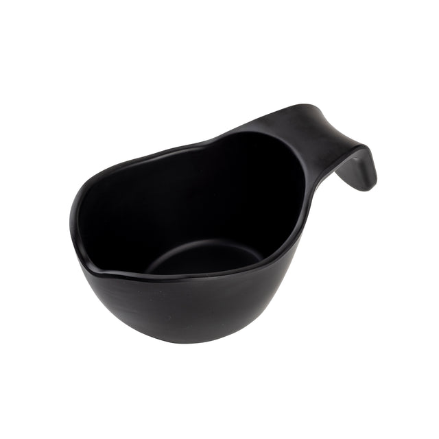 A black, asymmetrical TableCraft sauce boat with a curved handle on one end, photographed on a white background. The cup has a smooth matte finish and an organic, irregular shape, giving it a modern and minimalist appearance.