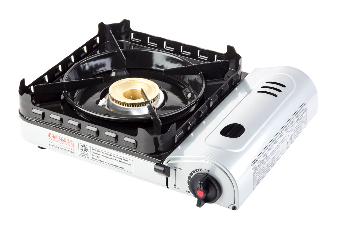 A portable, single-burner butane stove with a black metal grate on top, a round brass burner in the center delivering 15,000 BTU, and a white body featuring a control knob, vent slots, and safety labels. The stove is isolated on a white background.