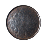 A round, dark ceramic plate from the Lunara Collection with a textured, mottled surface in shades of black and brown. This rustic TableCraft piece features a slightly raised rim and earthy appeal, photographed top-down against a white background.