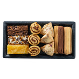 A rectangular Onyx Melamine Serving Tray holds assorted baked goods: brownies topped with chocolate and nuts, a yellow lemon bar, cinnamon swirl pastries, triangle-shaped pastries, and sandwich-style cookies with chocolate and vanilla filling.