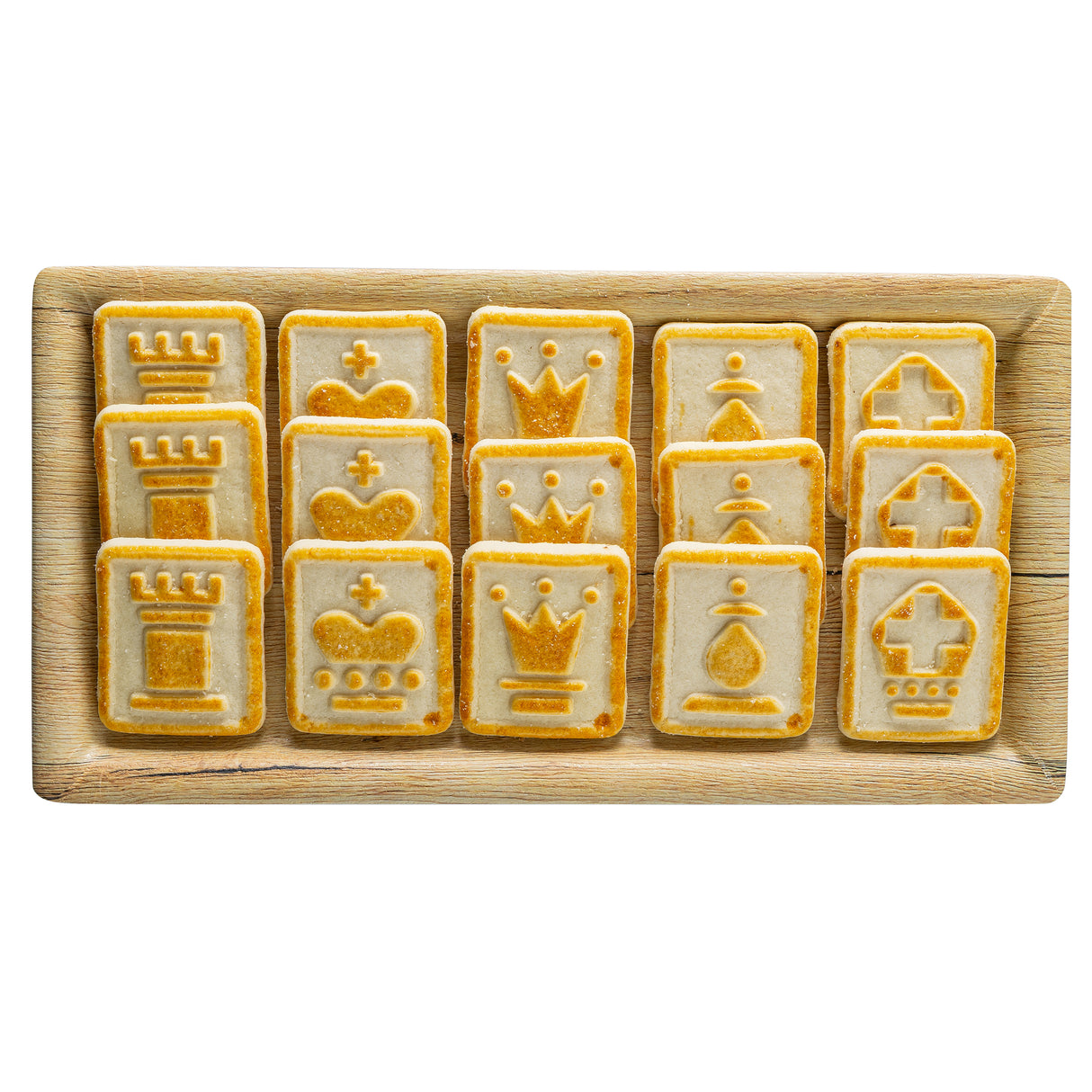 A wooden serving tray from the Timber Melamine Collection holds twelve rectangular cookies, each embossed with chess piece designs: rooks, kings, queens, pawns, and bishops. The cookies have a light golden crust with darker detailing.