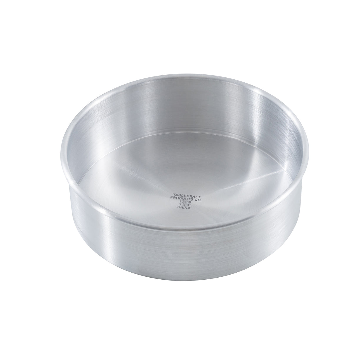 A round, deep, silver-colored TableCraft 12468 cheesecake pan features straight sides and a smooth interior surface. The bottom center is stamped with manufacturer information. The round aluminum pan is shown on a white background.