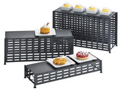 Three black BPA free lattice design metal display risers of varying heights hold small white plates with pastries and cupcakes. The arrangement showcases desserts on each tier, including cupcakes, a tart, a pastry, and a berry dessert.