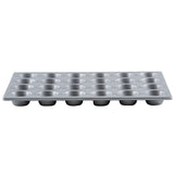 A silver non-stick muffin pan is shown from the side. It has four rows of six round muffin cups each, making a total of twenty-four cups. The pan’s shiny surface and evenly spaced cups are clearly visible against a plain white background.