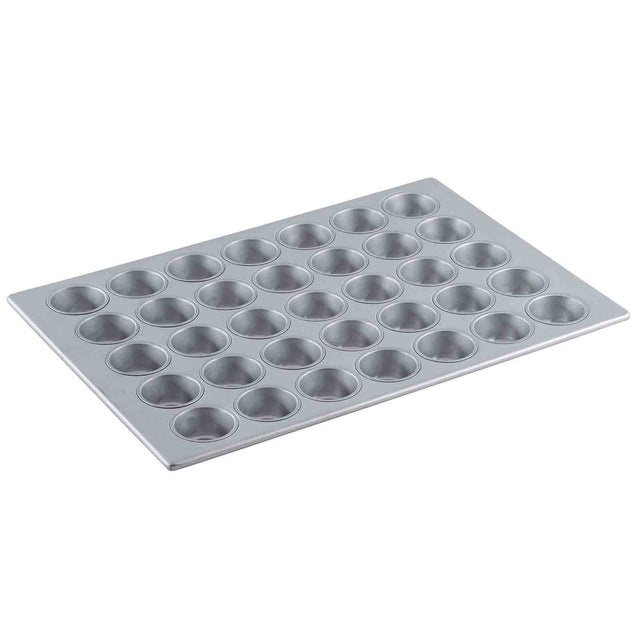 A large, rectangular, non-stick muffin pan or cupcake pan with 24 evenly spaced, round cups arranged in a 4 by 6 grid is placed on a white background. The tray is angled to show both depth and cup detail.