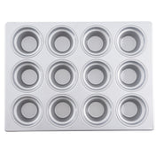 A silver 12 cup muffin pan with a silicone glazed non-stick coating is shown from above. The pan has three rows of four evenly spaced round wells, each with a circular base and smooth sides, on a flat rectangular metal tray.