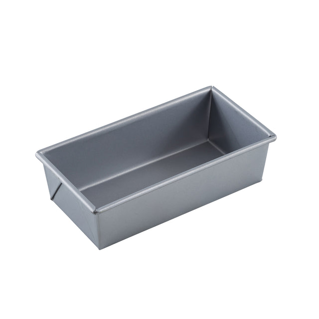 A rectangular, silver aluminized steel bread pan with straight sides and slightly rounded edges is shown from an angle on a white background. The loaf bread pan is empty and features a smooth, non-stick surface.