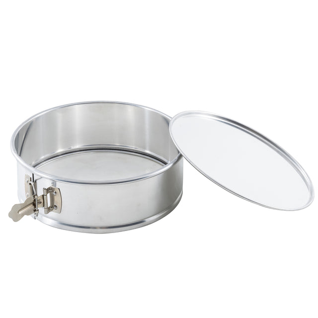 A round, stainless steel springform pan with a removable lid placed to the side. The pan has a metal latch on the left for secure closure, smooth shiny surfaces, and a snug-fitting lid matching its metallic finish.