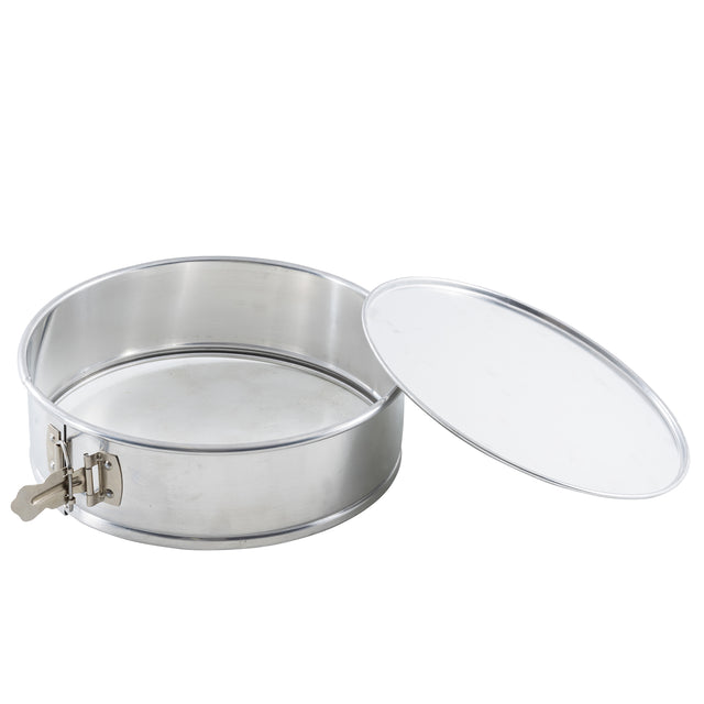 A round, aluminum springform pan with a removable flat lid is shown. The pan features a durable latch on the side for easy opening and closing. The lid is positioned to the right, resting slightly tilted and revealing the empty interior.