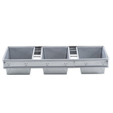 A rectangular aluminized steel bread pan divided into four equally sized square compartments, designed for baking multiple loaves or cakes at once. The pan has straight sides, a flat base, visible seams, and a durable non-stick coating.