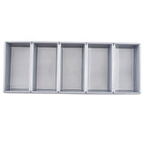 A rectangular silver organizer tray with five equal vertical compartments, seen from above. Featuring clean lines like a Bread Pan, it’s ideal for sorting office supplies or utensils. Its silicone glazed non-stick surface ensures easy cleaning; the interior appears empty.
