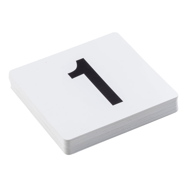 A stack of white PVC number cards lies on a white surface. The top card displays a large, bold black number 1 centered on it. The visible edges reveal multiple table numbers beneath the top card.