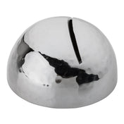 A shiny, stainless steel dome-shaped metal object with a silver hammered pattern and a single narrow slit on top, resembling a modern, minimalist coin bank or sculptural money box. The surface reflects light and surroundings.
