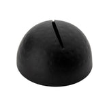A dome-shaped, matte black card holder with a narrow slit on top. The surface features a slightly hammered pattern, finished in black powder coated texture. Photographed against a plain white background, its purpose remains ambiguous.