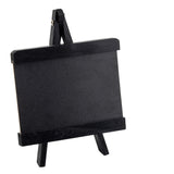 A small black chalkboard sits on a matching miniature wooden easel, both framed with thick black borders. This TableCraft tabletop board sign is empty and tilted slightly to the right, set against a plain white background.
